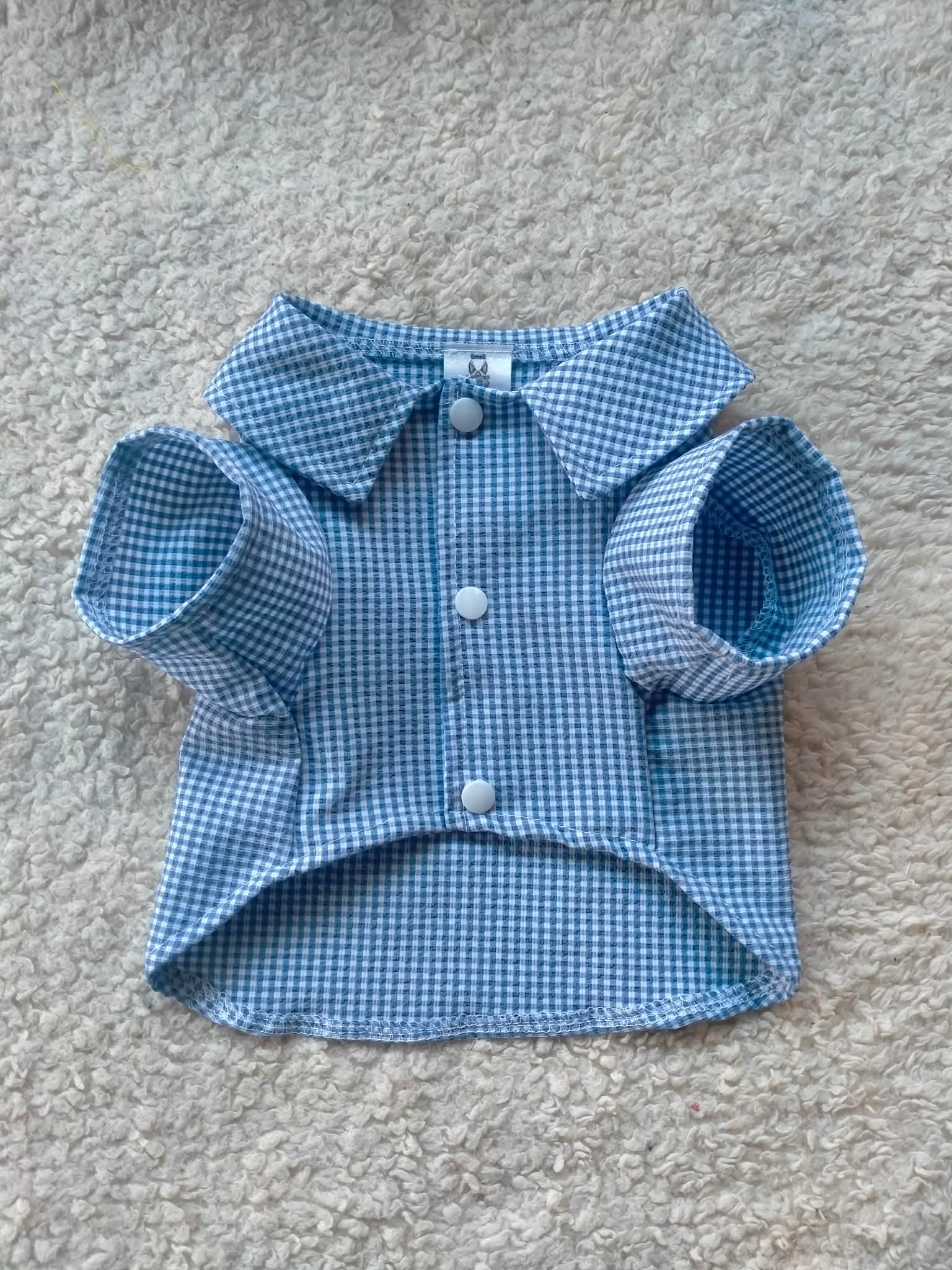 Blue checkered shirt for a small pet with short sleeves.