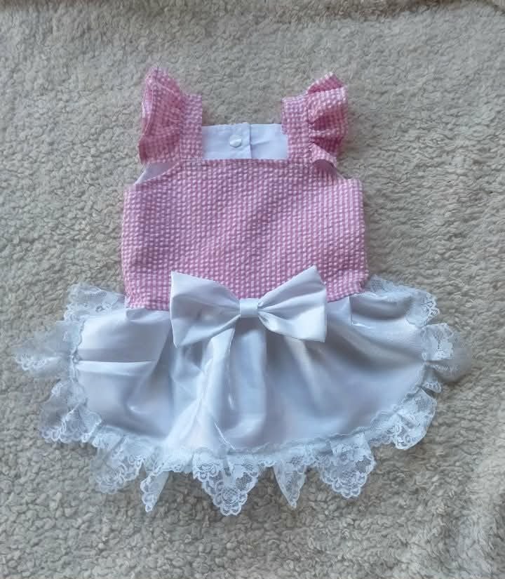 Pink and white baby dress with ruffles and lace.